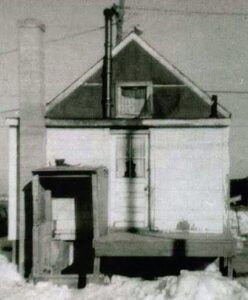 Black and white photo of an old, small house